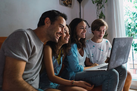 Content family watching laptop at home