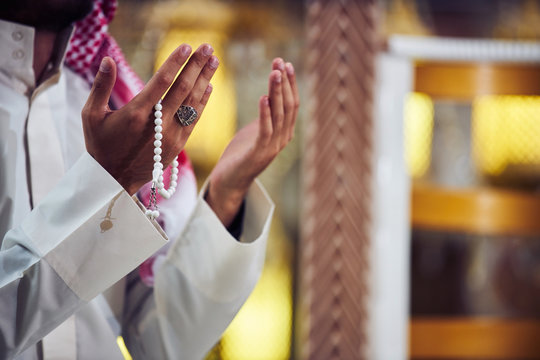 Hands holding tasbih of a religious man praying inside the mosque