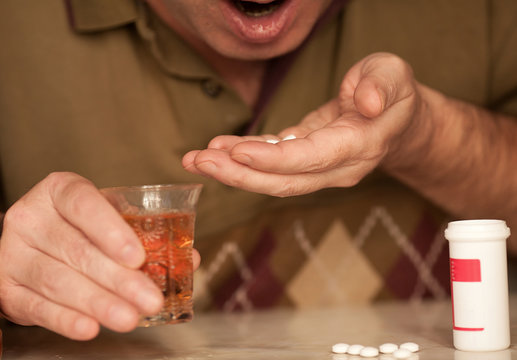 Close-up of older man sipping his drugs with alcohol