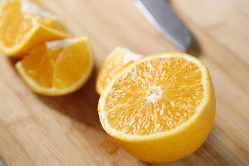 Closeup of fresh orange slices on a wooden cutting board.