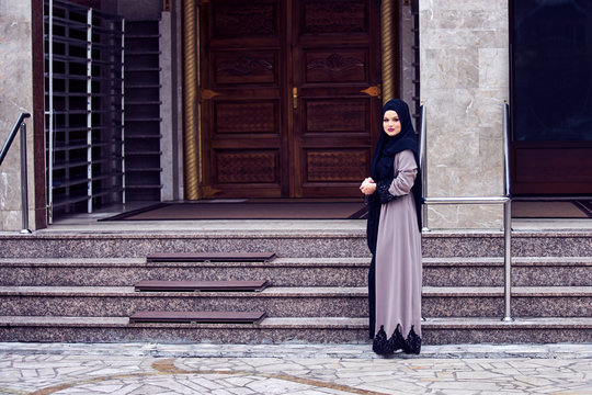 Portrait of a young religious woman wearing hijab in fron of mosque door