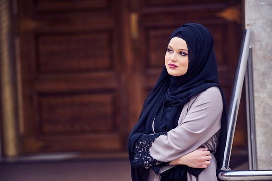 Portrait of a young religious woman wearing hijab in fron of mosque door