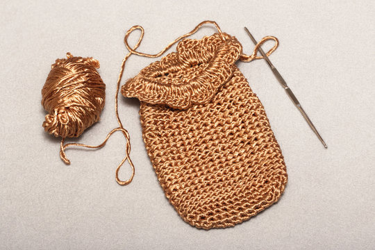 crocheting of viscose products, a small golden bag, a phone case, a golden thread with a metallic luster