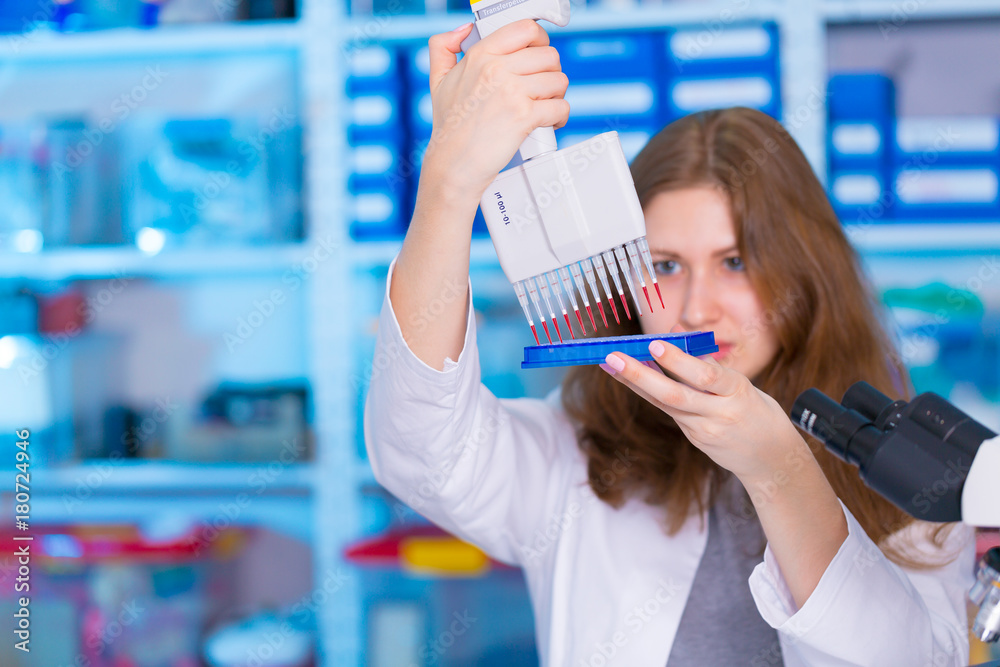 Wall mural laboratory female assistant with pipette