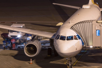 passenger airplane at an aiport gate at night