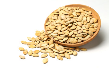 pumpkin seeds in wooden plate isolated on white background