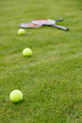 Racket and balls for tennis on green grass