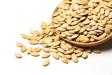 pumpkin seeds in wooden plate isolated on white background