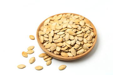 pumpkin seeds in wooden plate isolated on white background