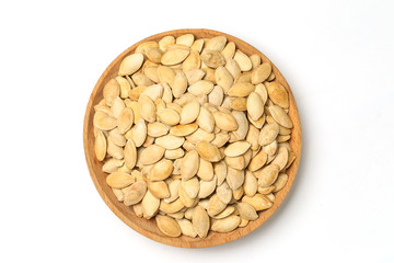 pumpkin seeds in wooden plate isolated on white background