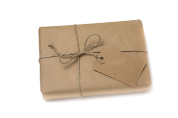 Christmas or New Year gift box wrapped in kraft paper with blank gift tag.