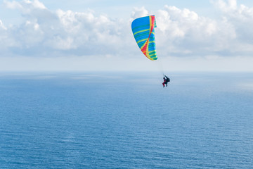 Flying a tandem paraglider over the sea with views of the horizon