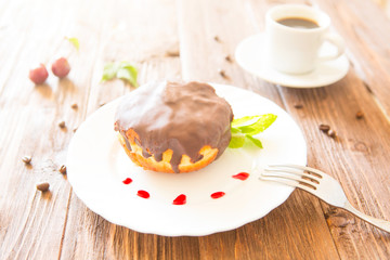 Chocolate donut or bun with an espresso on table