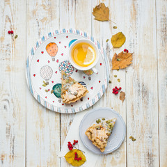 Autumn background with pumpkin pie, hot tea, yellowed leaves, book and rug. Perfect sunny autumn. A wooden light white autumn background for you. Copy Space. Place for text. Flat lay, top view