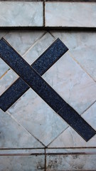 Cruz lateral em azulejo preta e branca