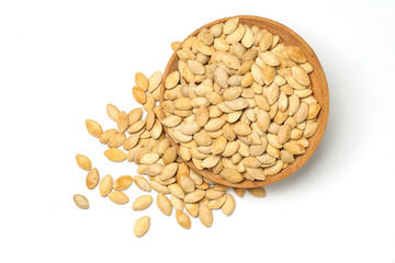 pumpkin seeds in wooden plate isolated on white background