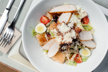 Classic Caesar salad served in the white plate