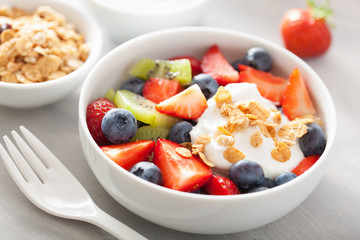 fruit berry salad with yogurt and granola for healthy breakfast