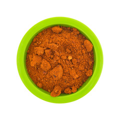 Top view of a small green bowl filled with Sriracha seasonings isolated on a white background.