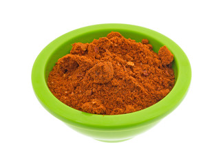 A small green bowl filled with Sriracha seasonings isolated on a white background.