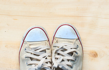 Old sneakers on  wooden floor background and have copy space for design in your work.