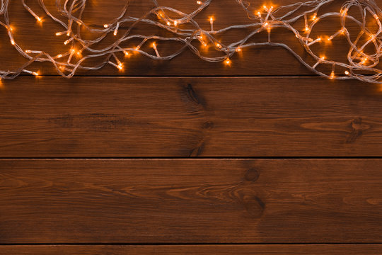 Christmas lights border on wood background