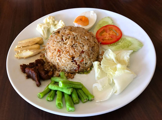 Thai style food, fried rice with chili paste served with salted egg, caramelized pork and fresh vegetable