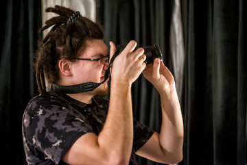 young hipster man taking pictures with a camera
