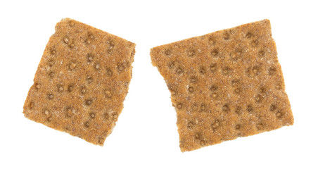 Top view of a broken sourdough whole grain crispbread cracker isolated on a white background.