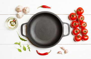 Cooking ingredients vegetables around the empty frying pan with copy space. Top view, flat lay.