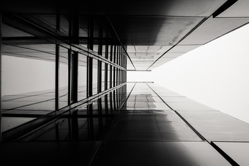 Abstract image of looking up at modern black glass building. Architectural exterior detail of...