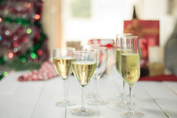 Christmas party drinking concept, glass of champagne with gift box on bokeh background .