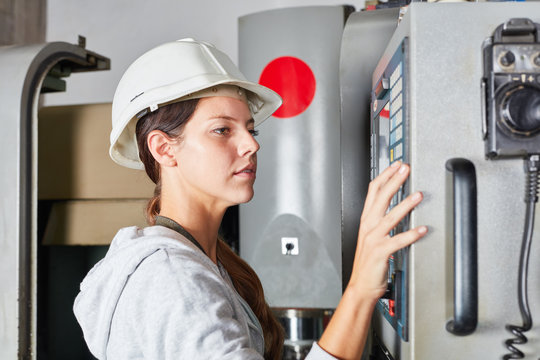 Frau als Arbeiter an der CNC-Maschine