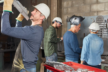 Arbeiter transportier ein Bauteil in der Fabrik