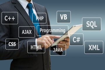 Businessman hand using digital tablet with virtual panel of programming languages, Computer technology concept