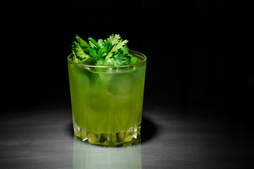 Glass of healthy green cocktail decorated with parsley leaves