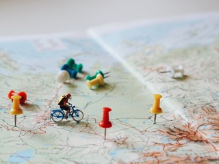 Miniature people with traveling concepts,riding bicycle on world map.