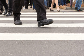 Crosswalk and anonymous people crossing the street.