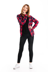 Happy young woman standing isolated over white wall