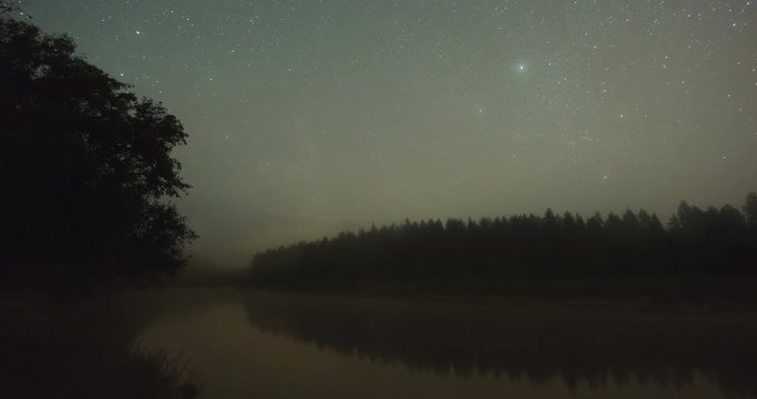 Time lapse of stars over river Gauja in forest with with incoming fog and clouds in Gauja National Park, Latvia