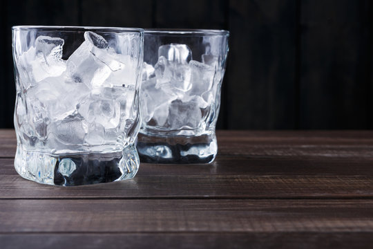 Glasses with ice cubes on dark background
