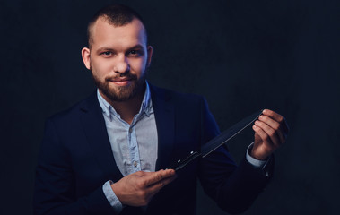 A man in a suit holds a Chef's knife.