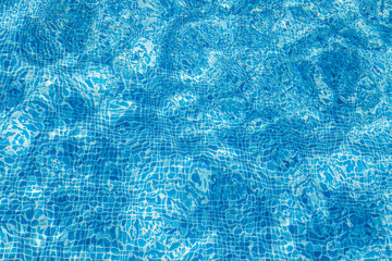 Texture Background of tiles on the bottom of the swimming pool. With distortions from water. With sunlight and glare and flare.