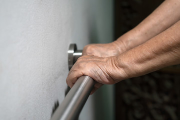 Elderly woman hand holding on handrail for support walking