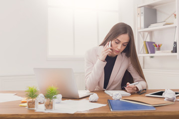 Serious business woman at work talking on phone