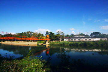 Fototapeta premium Orange steel bridge across on the river and mountain at countryside of Vangvieng,Laos