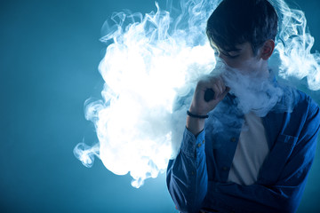dark-haired man vaping in cloud of smoke