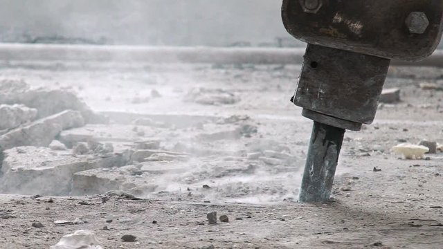 Professional electric tools for breaking the concrete cover. Clay digger in the process of work: close-up. Perforator for the destruction of concrete. Cracks on the floor from the work of a jackhammer