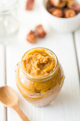 Homemade Healthy Raw Paleo Vegan Date Caramel Sauce on Light Wooden Background, Vertical View