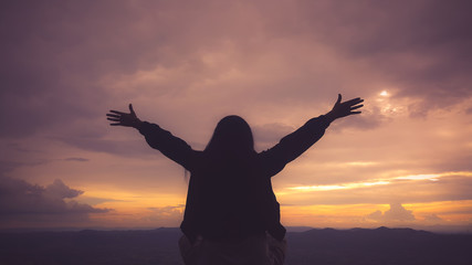 Silhouette freedom woman rise hands up to welcome a good day , open arms motivate enjoy and success the wish